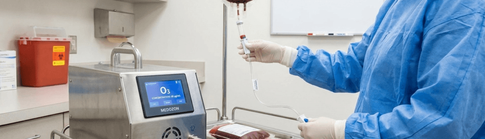 Photographie clinique montrant une séance d'auto-hémothérapie majeure pour ozonothérapie réalisée par un professionnel de santé avec générateur d'ozone médical calibré, en environnement hospitalier stérile.